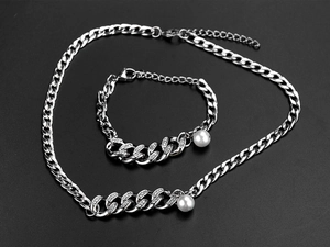 Detail view of silver Cuban link necklace with sparkling rhinestones and white pearls