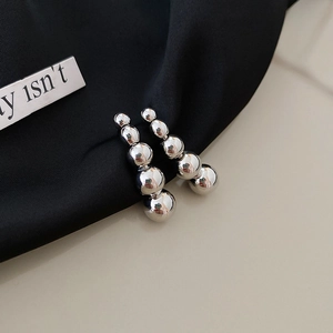 Minimalist silver bead drop earrings with a gradient of five polished metal spheres