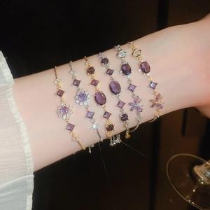 Elegant wrist detail featuring purple zircon butterfly and flower adjustable bracelets