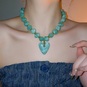 Detail of mint green marble acrylic heart necklace set with golden spacer beads