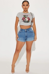 Detail of high-waist blue denim shorts with double buttons and retro graphic crop top