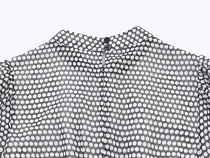 Close-up of retro polka dot chiffon dress featuring a high neck with back button closure