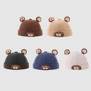 Flat lay of five corduroy baby beanies with cute bear ears and bear embroidery