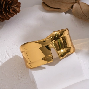 Close-up of a wide 18K gold plated stainless steel cuff with unique fluid wave texture