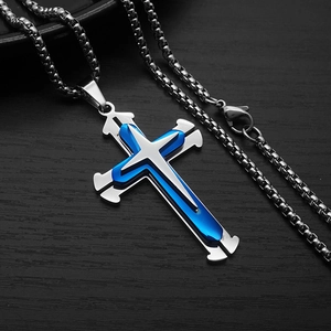 Detailed close-up of double-layer cross pendant in silver and blue on wood background