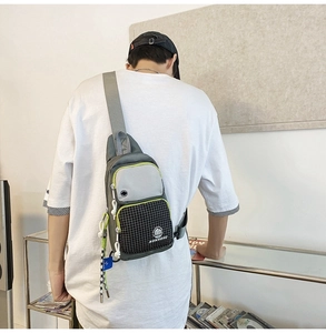 Detailed back view of a grey and black water-resistant chest bag with neon green piping
