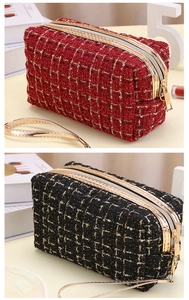 Details von roten und schwarzen Tweed-Kosmetiktaschen mit Goldfaden und Metall-Zipper