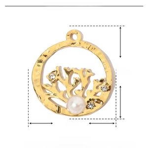Macro detail of golden stainless steel tree pendant with rhinestones and ABS pearl
