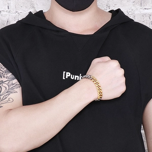 Close-up of dual-tone gold and silver Cuban link bracelet on a male model with street style