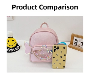Pink glitter mini backpack with heart window and bow, shown next to phone for size scale