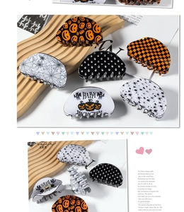 Detail of Halloween hair claws featuring pumpkin, spider web and skull acrylic patterns