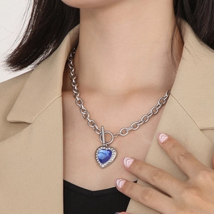 Detail of silver link chain with blue heart gemstone and T-bar toggle closure on model