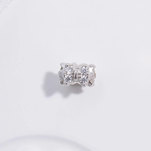 Detailed view of silver bow bead with sparkling zircon inlay for DIY jewelry crafting
