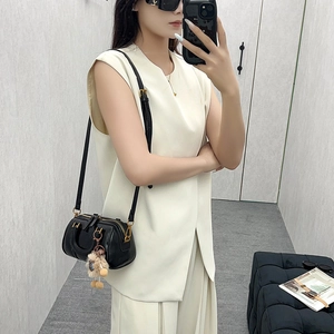 Black leather Boston bag with plush charm shown in a minimalist fashion outfit mirror selfie