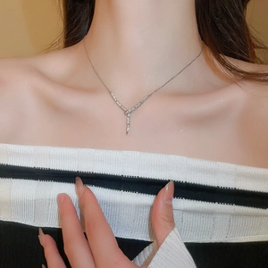 Close-up of silver Y-shaped snake necklace with sparkling zircon tassels on a female model