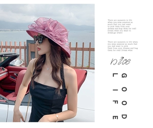 Close-up of pink organza beach hat with large floral decoration for sun protection