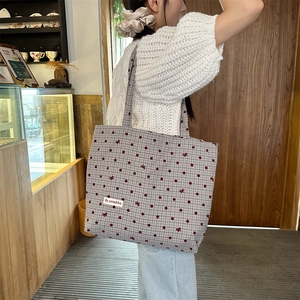 Détail du grand sac cabas en toile avec pois rouges et motif à carreaux vichy noir