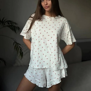 Women's two-piece white floral rib-knit pajama set with ruffled shorts and short sleeves