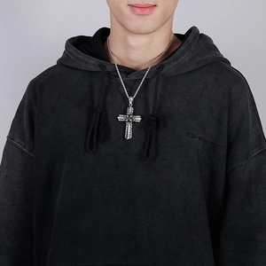 Male model wearing a vintage silver cross pendant with black detailing on a rope chain