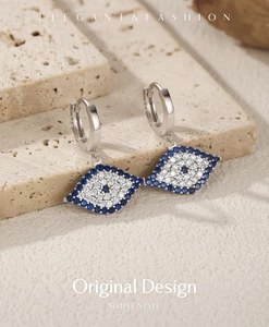 Macro shot of S925 silver evil eye hoop earrings with blue and white zircon pave setting