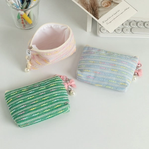 Detailed view of tweed coin purses with pearl bow charms in various pastel colors