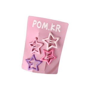 Set of four colorful matte star hair clips in pink and purple on display card