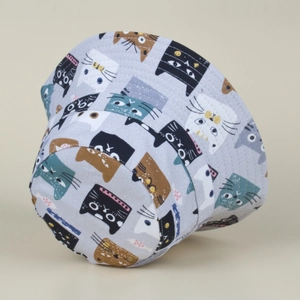 Detailed view of grey bucket hat with colorful cartoon cat print on high-quality fabric