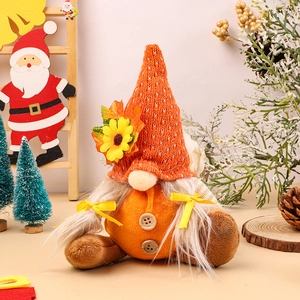 Détail d'un gnome de récolte avec bonnet orange tricoté, tournesol et feuille d'érable