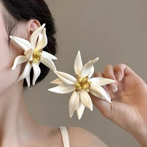 Elegant white floral pearl earrings with yellow center worn by model for luxury look