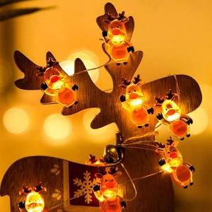 Close-up of reindeer LED string lights with warm yellow glow and wooden festive decor