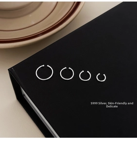 Set of four S999 sterling silver minimalist hoops in various sizes on black display