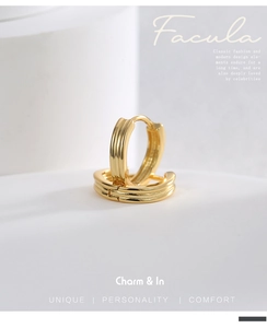 Detail shot of gold-plated hoop earrings with triple-line texture on a minimalist base