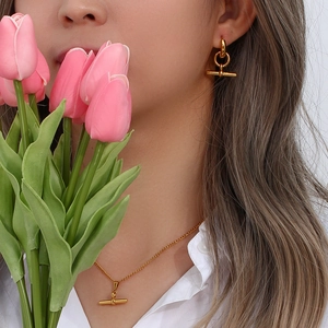 Detailed view of a gold necklace set with T-bar closure and geometric circular pendants