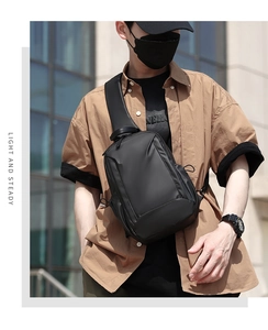 Close-up of black waterproof crossbody chest bag with adjustable strap on a male model