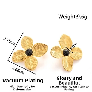 Macro detail of gold flower earrings with brushed texture and black marble beads