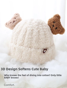 Close-up of soft beige fleece baby bear hat with cute ears on white fluffy clouds