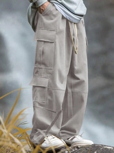 Dettaglio delle tasche cargo e della coulisse sui pantaloni da esterno kaki da uomo