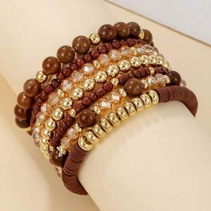 Close-up of bohemian layered beaded bracelets in brown and amber acrylic crystal tones