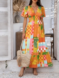 Detail of bohemian V-neck maxi dress featuring tropical leaf patterns and elastic waist