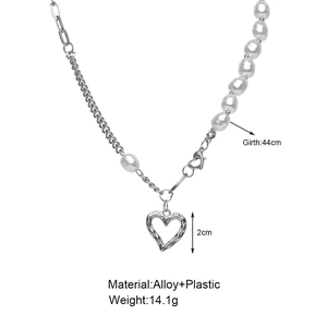 Detailed view of white pearl and silver alloy chain necklace with hollow heart pendant