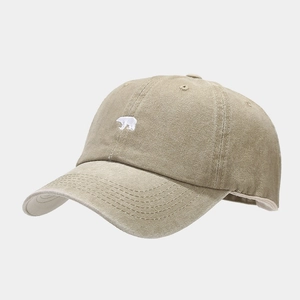 Close-up of white polar bear embroidery on khaki washed cotton baseball cap texture