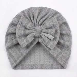 Close-up of baby turban hat in gray knit fabric featuring a large decorative bow
