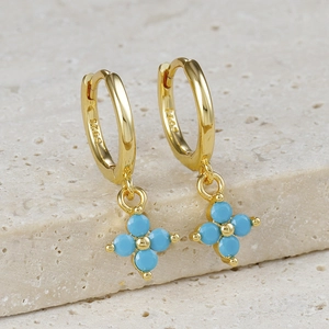 Close-up of S925 sterling silver stamp on golden hoop earring with blue flower petal charm