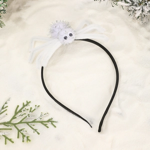Detail of white furry spider headband with glitter accents on a festive winter background