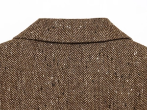 Macro view of brown herringbone tweed texture and notch lapel seam on the blazer