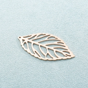 Macro view of a rose gold leaf pendant with minimalist hollow-out pattern and smooth texture
