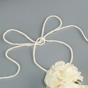 Detailed view of handmade cream floral neck accessory with elegant chiffon fabric knotting