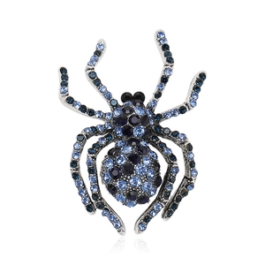 Detailed view of vintage alloy spider brooch featuring blue and black crystals on suit coat
