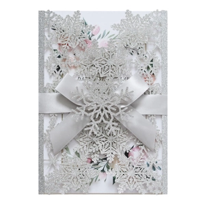 Silver glitter snowflake laser cut wedding invitation with an elegant grey ribbon bow