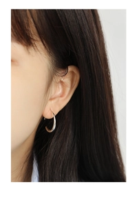 Close-up of minimalist silver C-shaped hoop earring on model with a polished finish